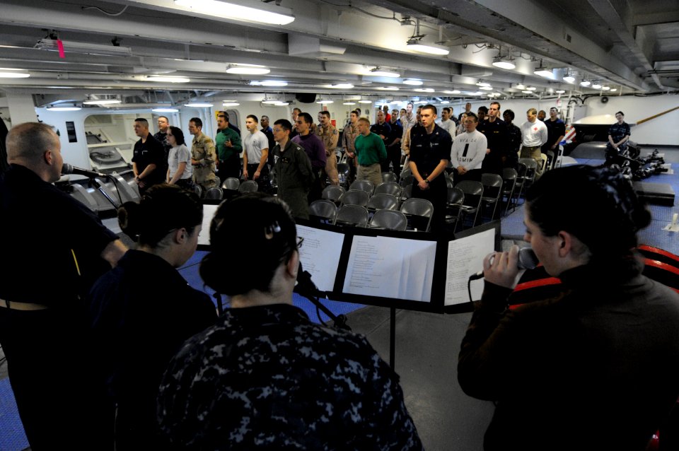 US Navy 110213-N-8040H-032 Sailors sing gospel hymns on the focisle during a non-denominational Christian service aboard the Nimitz-class aircraft
