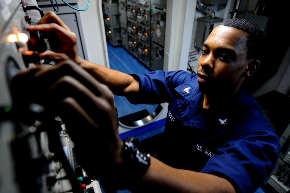US Navy 110215-N-8040H-093 Information Systems 3rd Class Jamonte Reed verifies the azimuth and elevation for voice circuits in the satellite commun