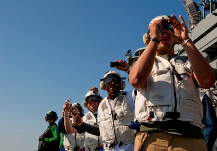 US Navy 110216-N-DR144-404 Green Bay Packers linebacker Frank Zombo and cornerback-safety Jarret Bush take photos and cheer while watching aircraft