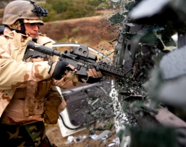 US Navy 110218-N-OT964-197 Mass Communication Specialist 3rd Class Jonathon Chandler breaks a window on a car during an ambush drill as part of a W