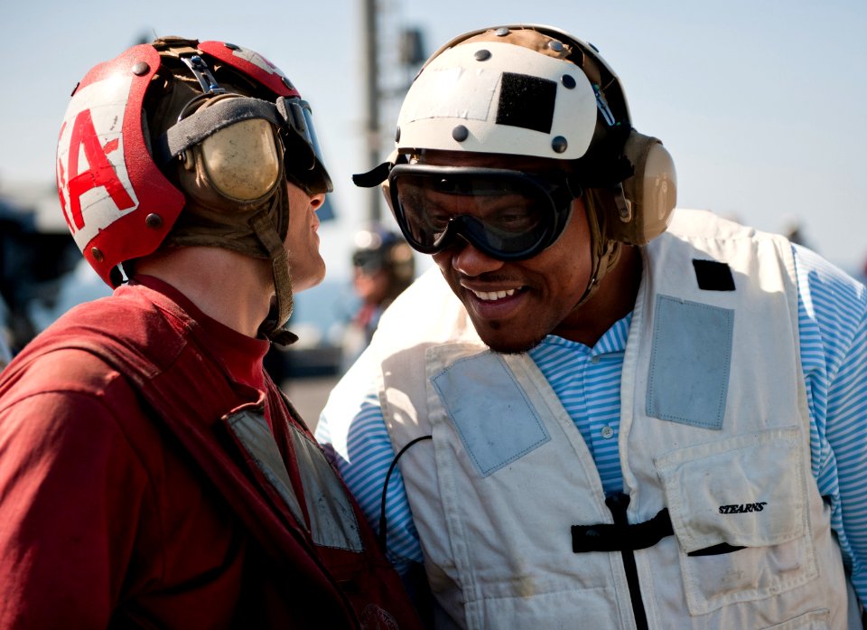 US Navy 110216-N-DR144-199 William Henderson, a fullback for the Green Bay Packers football team, speaks with an aviation ordnanceman on the flight
