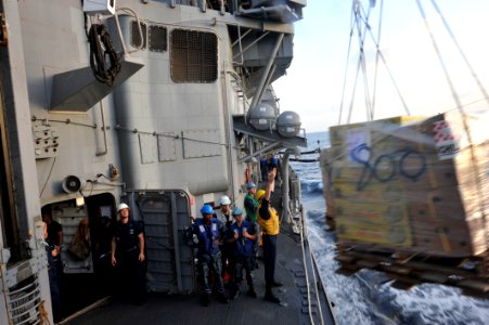 US Navy 110217-N-6006S-030 Boatswain's Mate 3rd Class John Dahlstrom signals pallet distance to the crew aboard the Military Sealift Command fleet