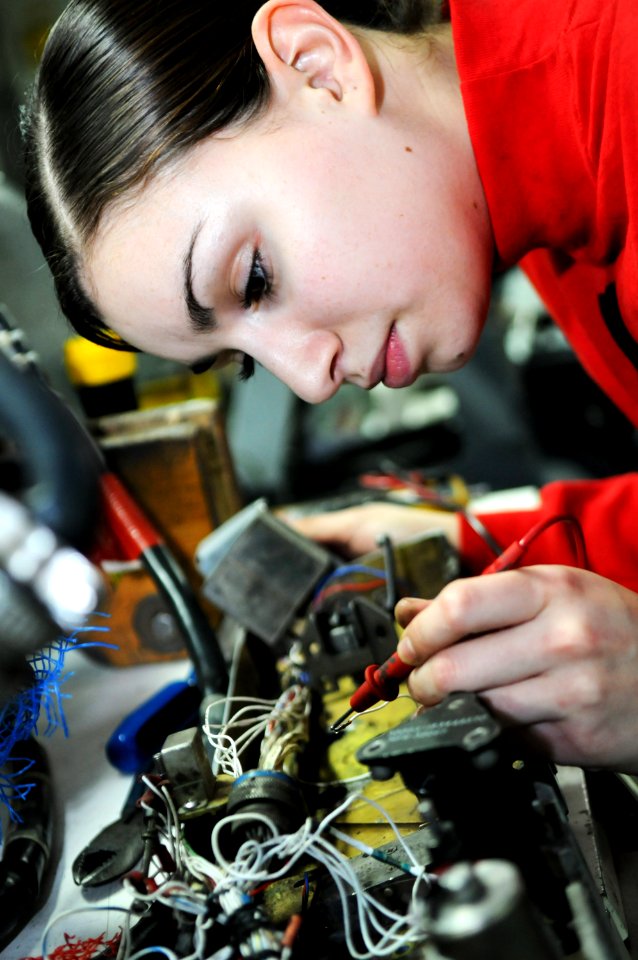 US Navy 110223-N-IC111-027 Aviation Ordnanceman Airman Irma Monje tests the circuit of a bomb racking unit of an F-A-18 Hornet in the gun shop aboa
