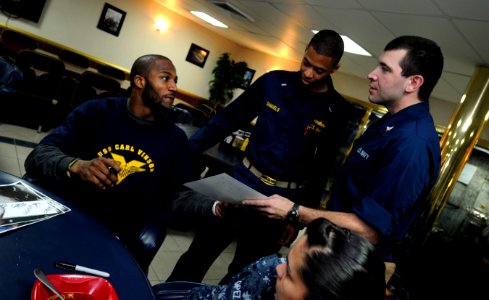 US Navy 110217-N-8040H-454 Jarrett Bush, a cornerback and safety for the Green Bay Packers, signs an autograph for a Sailor aboard the Nimitz-class