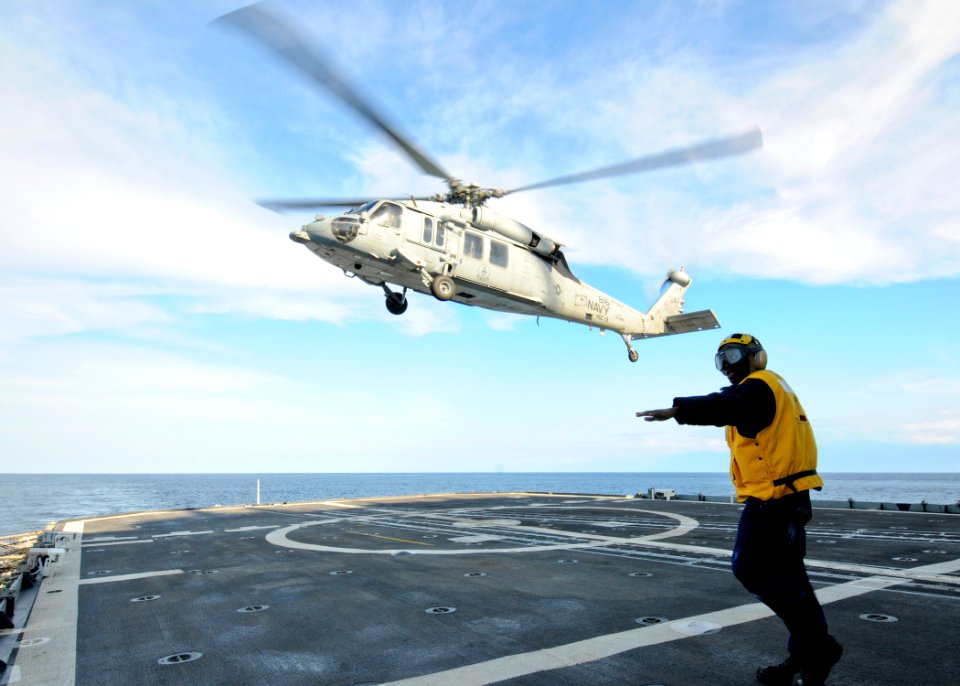 US Navy 110217-N-9793B-186 Boatswain's Mate 2nd Class Tyrone Williams directs an MH-60S Sea Hawk helicopter assigned to Helicopter Sea Combat (HSC)