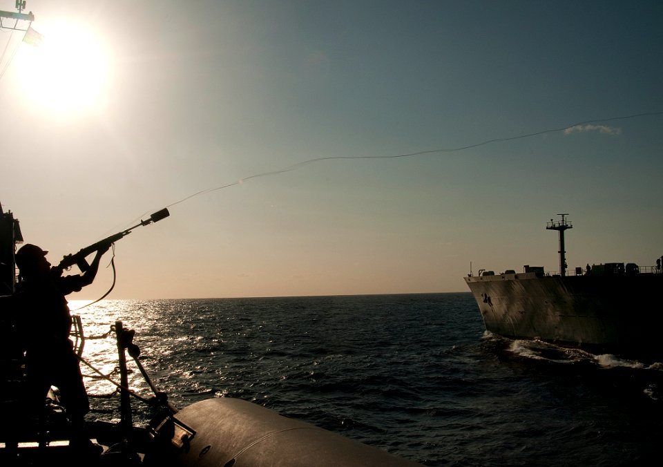 US Navy 110220-N-9589S-204 Gunner's Mate Seaman Apprentice Salvador S. Barwick fires a messenger line from the Arleigh Burke-class guided-missile d