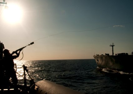 US Navy 110220-N-9589S-204 Gunner's Mate Seaman Apprentice Salvador S. Barwick fires a messenger line from the Arleigh Burke-class guided-missile d