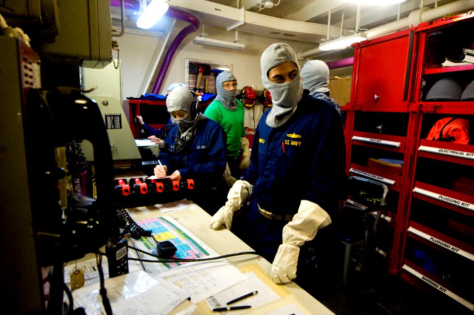 US Navy 110219-N-2953W-161 Lt. j.g. Kevin Samuel communicates with a damage control training team member during a general quarters drill aboard the