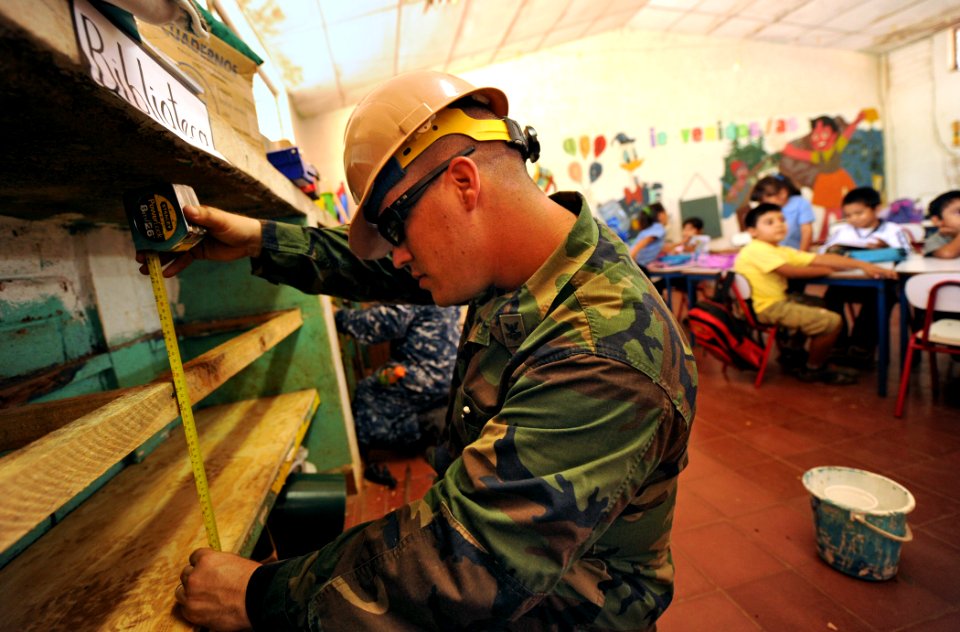 US Navy 110221-N-EC642-402 Builder 1st Class Clifton Horn takes measurements of book shelves at Centro Escolar Republica de Honduras during a weekl
