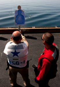 US Navy 110218-N-DR144-225 Aviation Ordnanceman 3rd Class Jacob Lopez assists Rear Adm. Samuel Perez, commander of Carrier Strike Group 1