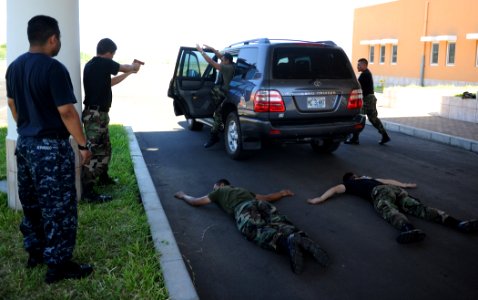 US Navy 110224-N-WX845-108 Master-at-Arms 2nd Class Henry Alvarado, left, observes a traffic felony stop demonstration by El Salvadoran sailors dur