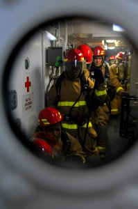 US Navy 110303-N-7730P-035 The primary fire team prepares to enter a generator room to battle a simulated fuel fire during a general quarters drill