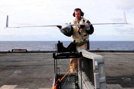 US Navy 110226-N-RC734-107 Jon Wingard, a Scan Eagle operator and maintainer from Insitu Group, places an Scan Eagle unmanned aerial vehicle on it