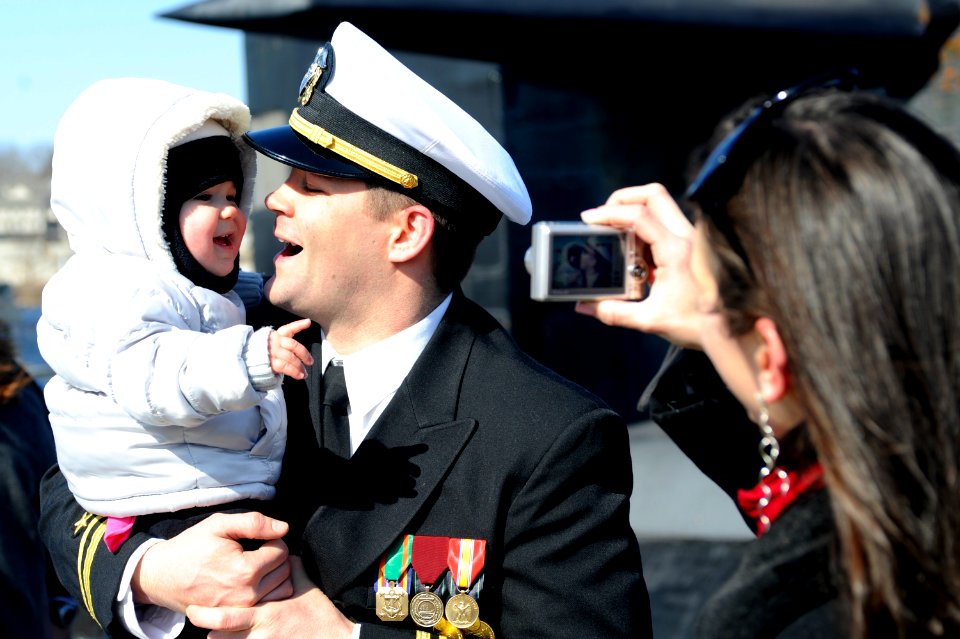 US Navy 110302-N-8467N-005 Lt. j.g. Jeremy Leazer gets his picture taken with his 14-month-old daughter by his wife moments after returning home fr