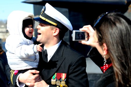 US Navy 110302-N-8467N-005 Lt. j.g. Jeremy Leazer gets his picture taken with his 14-month-old daughter by his wife moments after returning home fr