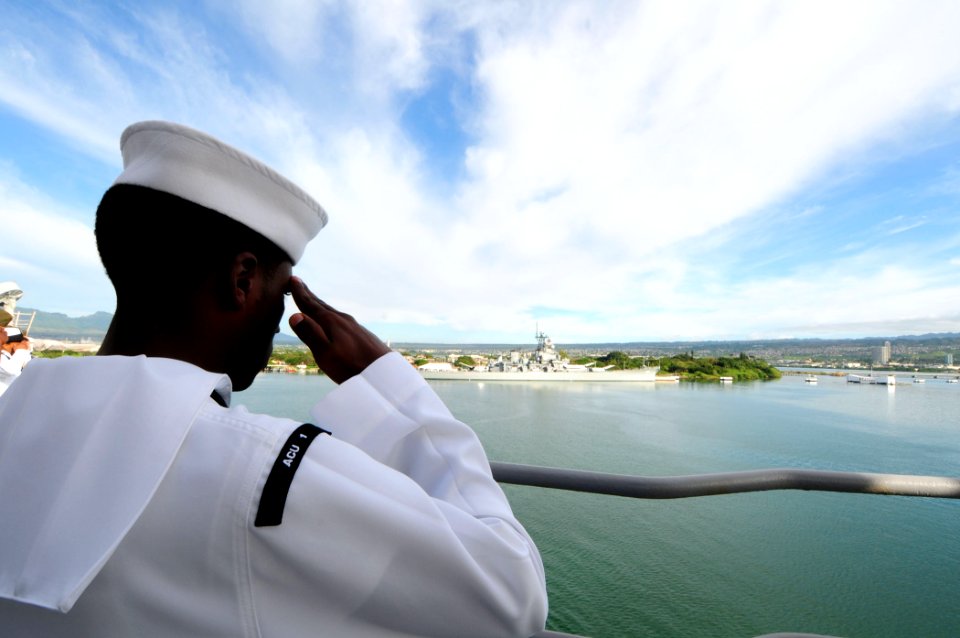 US Navy 110301-N-RC734-070 Engineman Fireman Broderick Smith renders a hand salute as the amphibious dock landing ship USS Comstock (LSD 45) passes