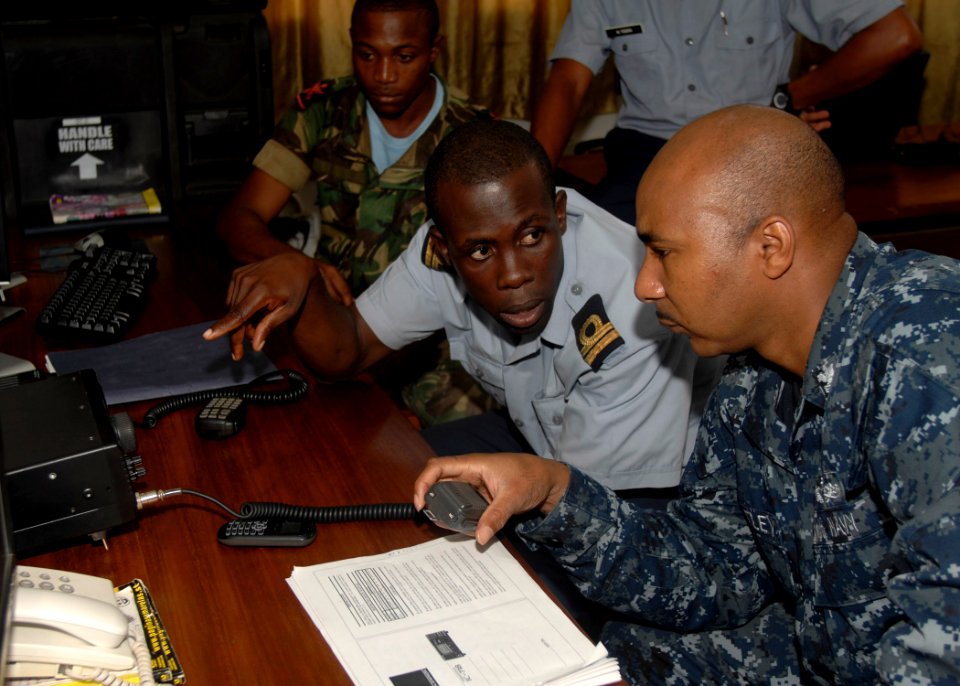 US Navy 110301-N-HI707-170 perations Specialist 1st Class Willie Bentley works to increase the range on a high frequency radio at the coast guard s