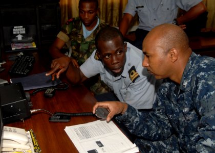 US Navy 110301-N-HI707-170 perations Specialist 1st Class Willie Bentley works to increase the range on a high frequency radio at the coast guard s