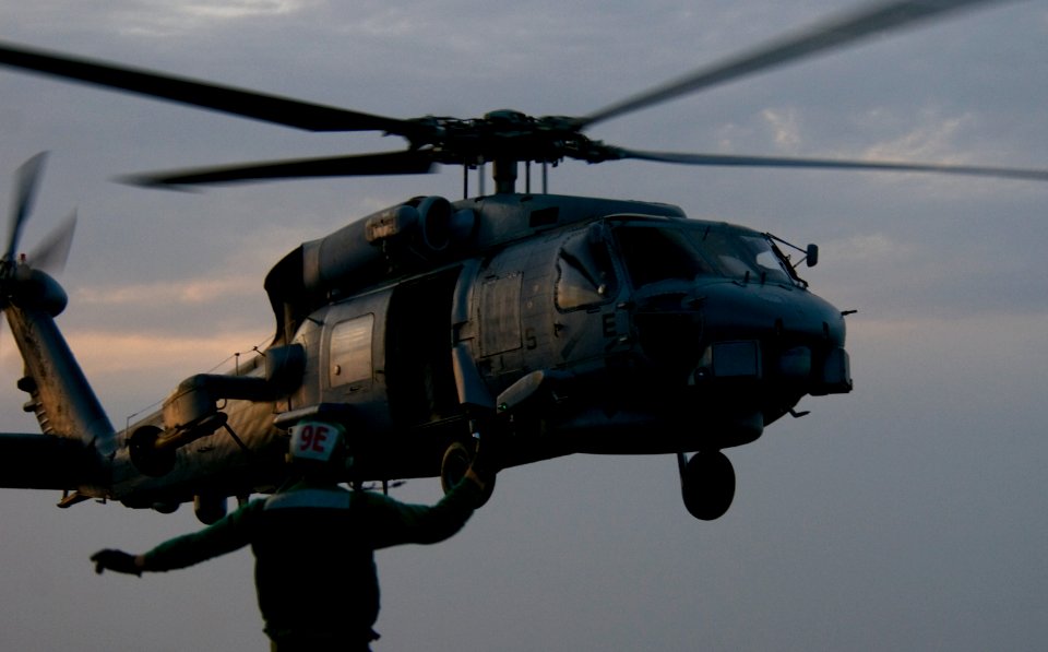 US Navy 110305-N-6320L-180 Aviation Electrician's Mate 3rd Class Matthew Bohan uides an SH-60F Sea Hawk helicopter as it departs USS Carl Vinson (C