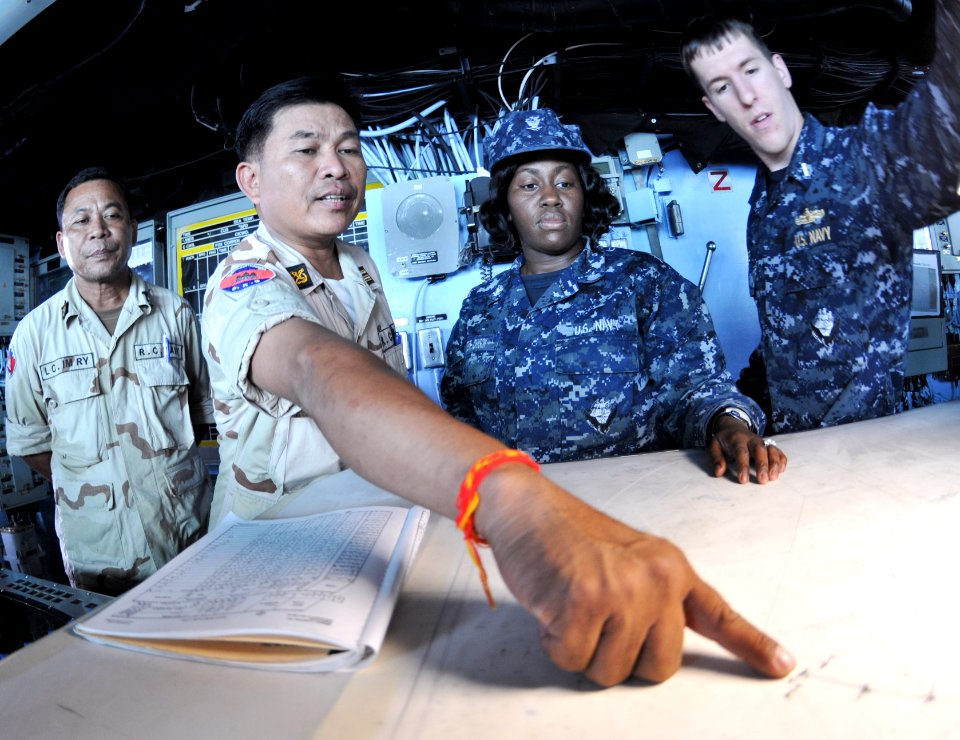 US Navy 110227-N-9950J-063 Royal Cambodian Navy Cmdr. In Sokhemra points out a course on the chart table during a tour of the forward-deployed amph