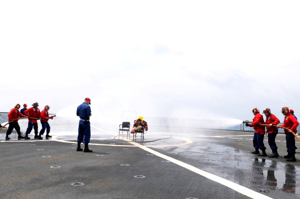US Navy 110228-N-6692A-077 Sailors charge fire hoses to simulate fighting a class bravo fire aboard the amphibious dock landing ship USS Germantown