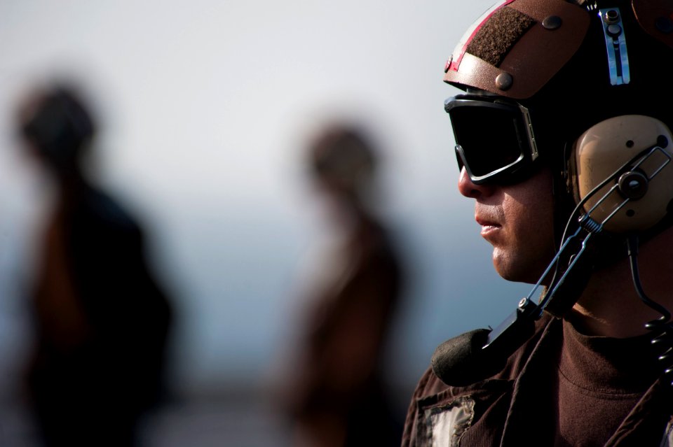 US Navy 110308-N-DR144-122 Aviation Ordnanceman 1st Class Robert Hamblin watches as aircraft are taxied for launch on the flight deck of the Nimitz