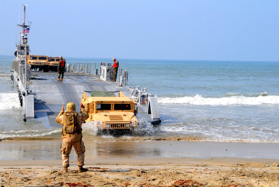 US Navy 110304-N-1786N-109 A Sailor directs a high mobility multipurpose wheeled vehicle from a causeway ferry during roll-on-roll-off discharge fa