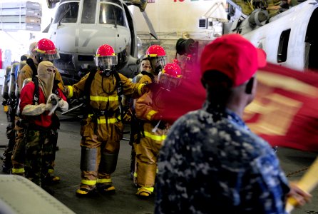 US Navy 110305-N-5538K-114 Sailors advance on a simulated fire in the hangar bay aboard USS Essex (LHD 2)