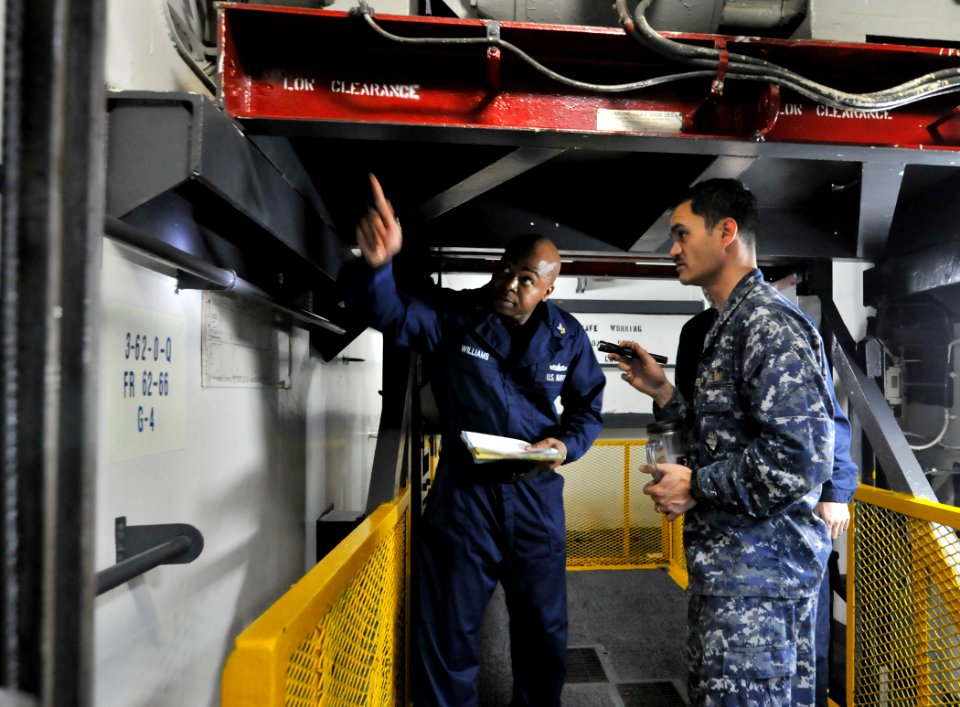 US Navy 110302-N-3852A-357 Machinist's Mate 2nd Class Clifford Williams, left, and Chief Religious Program Specialist Terry A. Burrell check for ma
