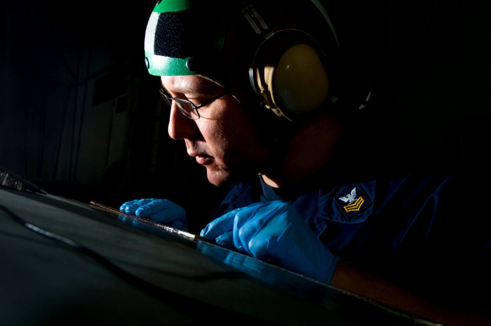 US Navy 110309-N-7488A-177 Aviation Structural Mechanic 1st Class Charles Martens performs an ultrasonic inspection on a horizontal stabilizer of a
