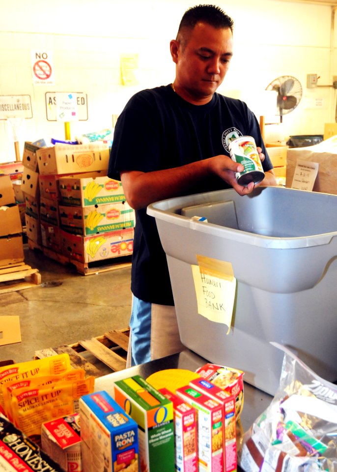 US Navy 110302-N-KT462-113 Culinary Specialist 1st Class Raymund Lee checks expiration dates on nonperishable goods at the Hawaii Food Bank