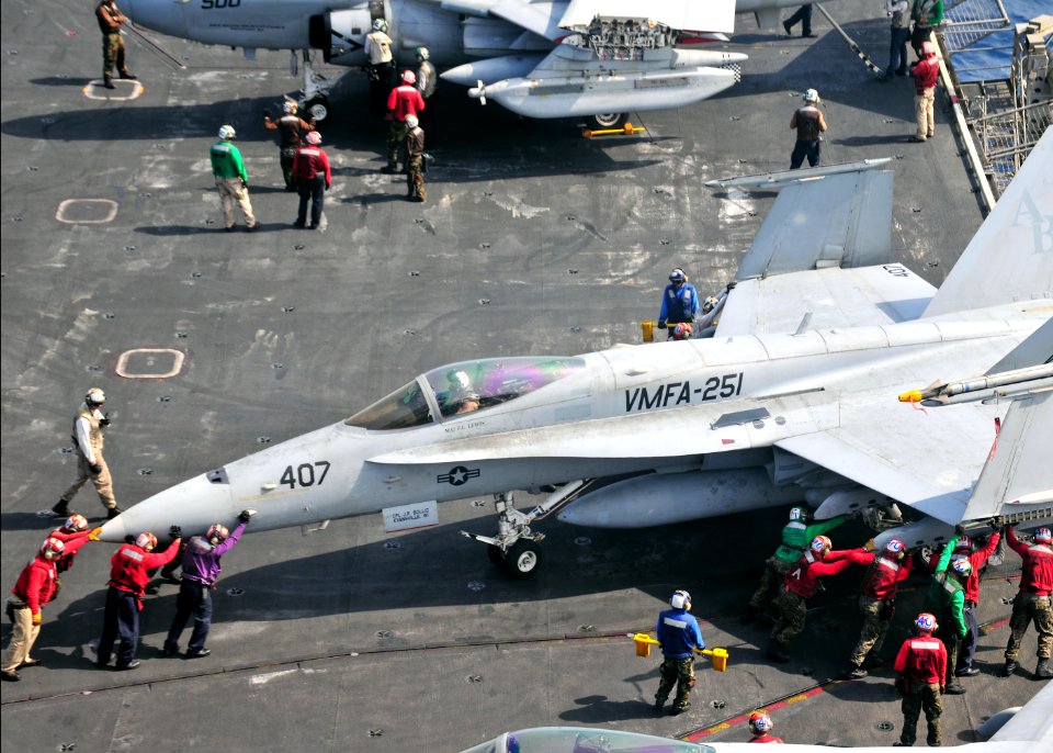 US Navy 110308-N-0074G-013 Sailors move an F-A-18C Hornet assigned to the Thunderbolts of Marine Strike Fighter Squadron (VMFA) 251 into a designat
