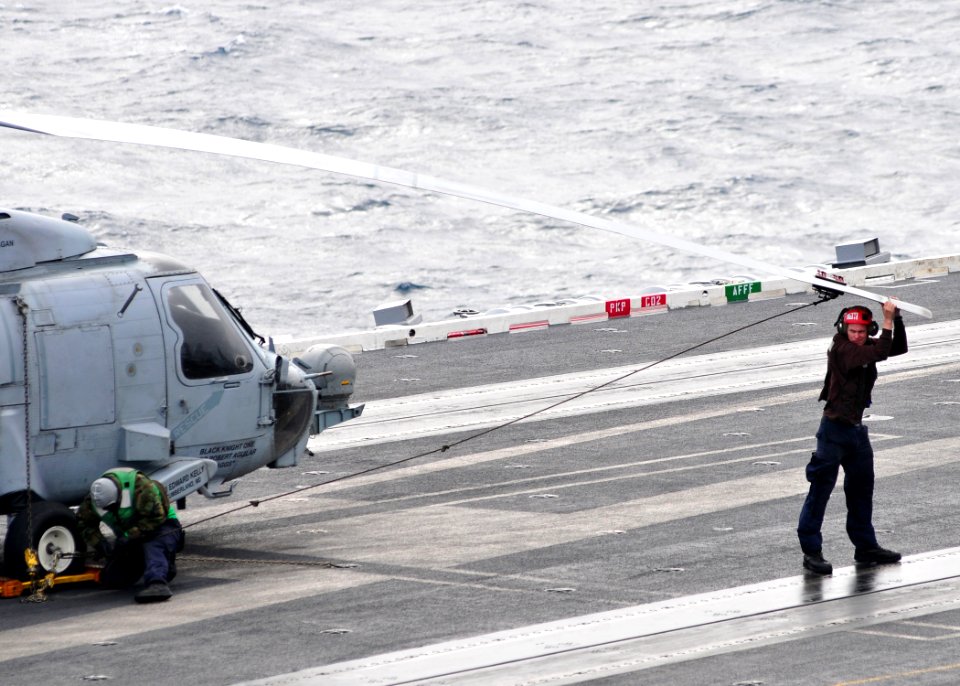 US Navy 110308-N-DM338-130 Sailors tie down the rotor blades of an HH-60H Sea Hawk helicopter assigned to the Black Knights of Helicopter Anti-Subm