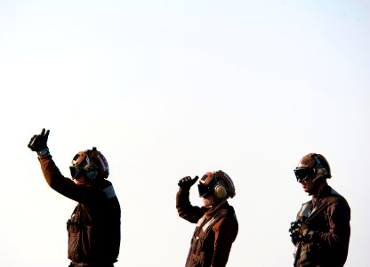 US Navy 110308-N-DR144-167 Sailors signal to the pilots of an E-2C Hawkeye on the flight deck of the Nimitz-class aircraft carrier USS Carl Vinson