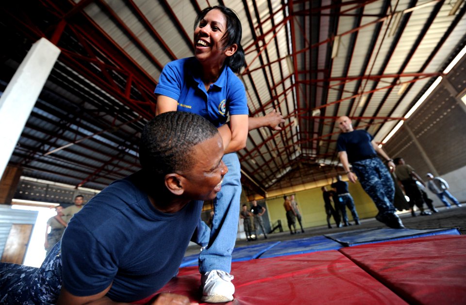 US Navy 110309-N-EC642-149 Maria Martinez, a Honduran port security guard, takes down Senior Chief Master-at-Arms Charles E. Mobley, assigned to a