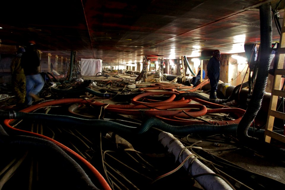 US Navy 110307-N-ZC343-294 National Steel and Shipbuilding Company employees work beneath the hull of the 40,500-ton USS Bonhomme Richard (LHD 6)
