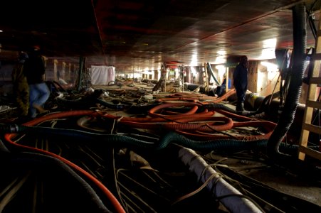 US Navy 110307-N-ZC343-294 National Steel and Shipbuilding Company employees work beneath the hull of the 40,500-ton USS Bonhomme Richard (LHD 6)