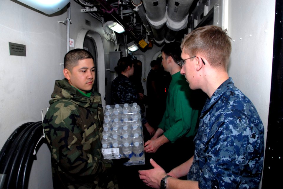 US Navy 110314-N-KF029-060 Sailors aboard the aircraft carrier USS Ronald Reagan (CVN 76) move cases of drinking water aboard the aircraft carrier