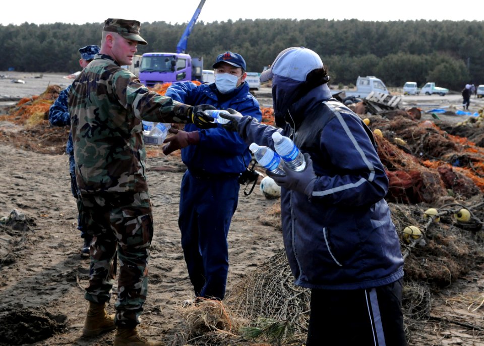 US Navy 110314-N-MU720-113 Chief Construction Mechanic Michael Robb, from Port Hueneme, Calif., assigned to Naval Air Facility Misawa, hands out wa