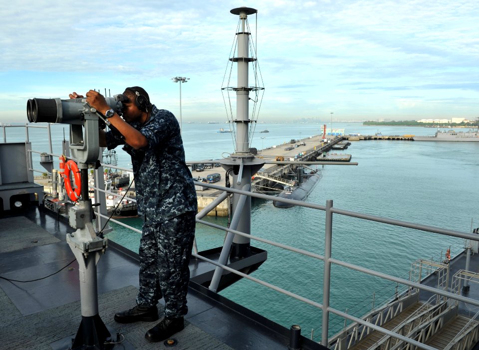 US Navy 110312-N-0864H-280 Operations Specialist 3rd Class Anthony Wilson looks through the