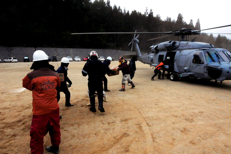 US Navy 110315-N-5503T-437 Japanese citizens move food and water out of an HH-60H Sea Hawk helicopter assigned to the Black Knights of Helicopter A
