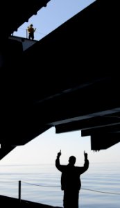 US Navy 110312-N-6505H-127 Sailors raise aircraft to the flight deck on an aircraft elevator aboard the Nimitz-class aircraft carrier USS Carl Vins