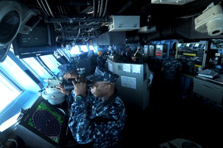 US Navy 110313-N-4743B-005 Sailors on the bridge of the forward-deployed amphibious assault ship USS Essex (LHD 2) navigate the ship to the coast o