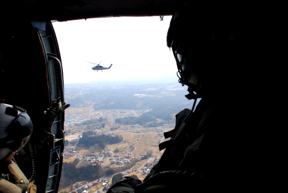 US Navy 110313-N-SB672-010 Sailors look out the starboard door as they prepare to deliver supplies during earthquake and tsunami relief efforts nea