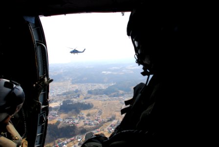 US Navy 110313-N-SB672-010 Sailors look out the starboard door as they prepare to deliver supplies during earthquake and tsunami relief efforts nea