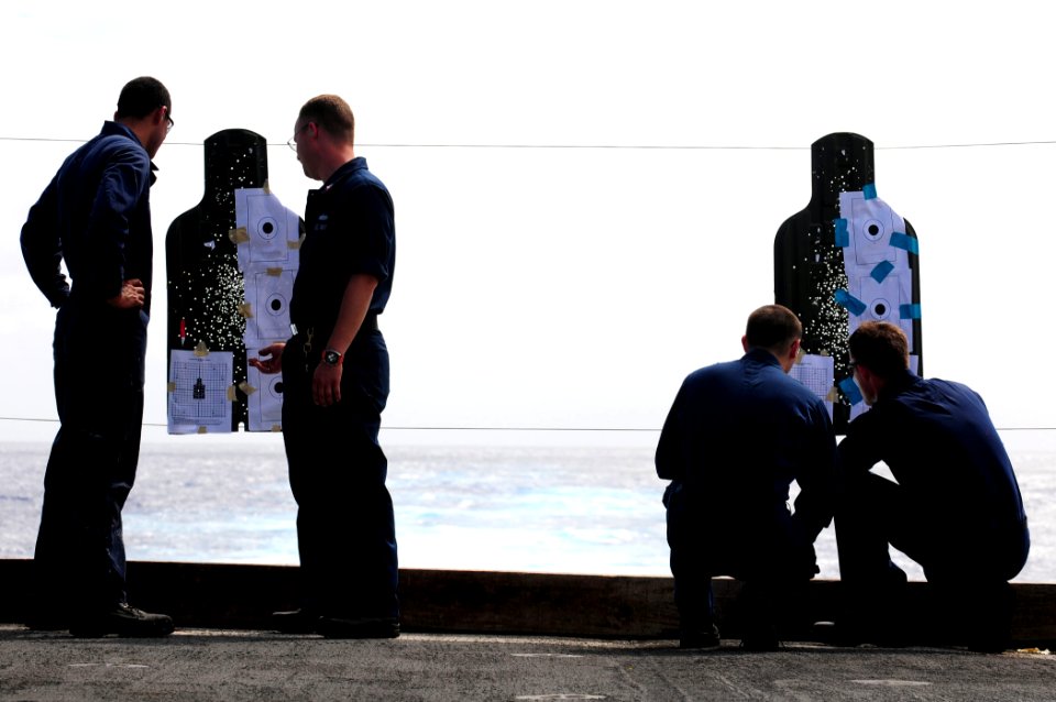 US Navy 110311-N-RC734-054 Line coaches and shooters examine targets during a small-arms live-fire exercise aboard the amphibious dock landing shi