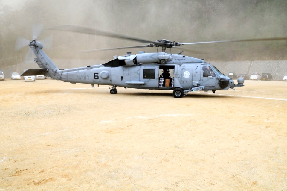 US Navy 110315-N-IC111-113 Sailors wait for Japanese citizens to take humanitarian supplies from an HH-60H Sea Hawk helicopter assigned to the Blac