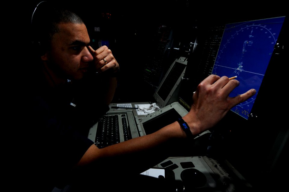 US Navy 110314-N-8040H-034 Operations Specialist 2nd Class Aaron Paul stands watch in the combat direction center aboard USS Carl Vinson (CVN 70)