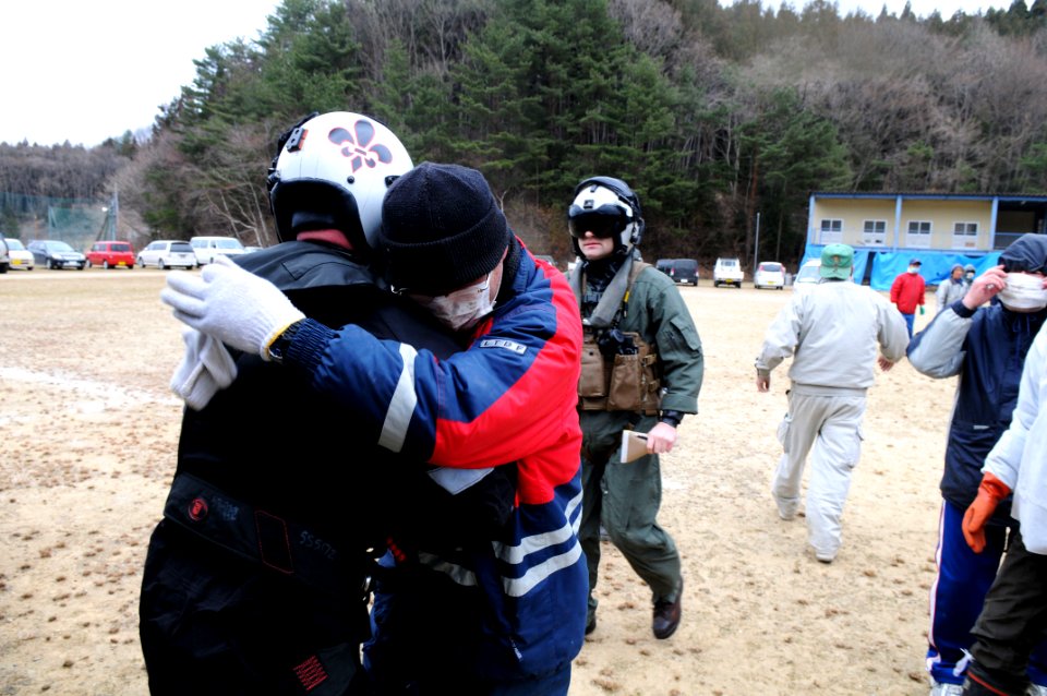US Navy 110315-N-IC111-461 Chief Naval Air Crewman Steven Sinclair is embraced by a Japanese citizen after delivering humanitarian supplies