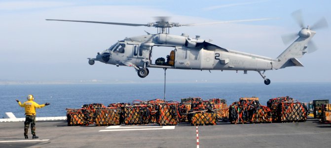 US Navy 110316-N-3729D-247 Aviation Boatswain's Mate (Handling) 3rd Class Joseph Glass directs an MH-60S Sea Hawk helicopter aboard the amphibious